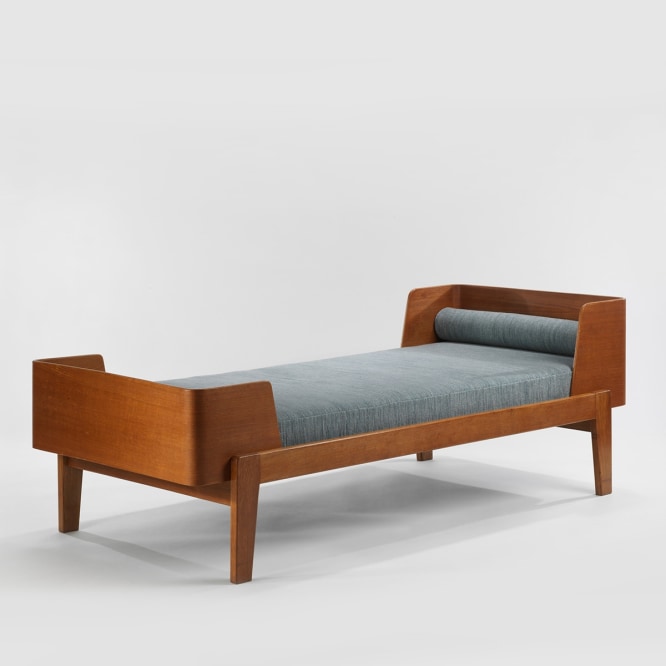wood daybed in an empty room