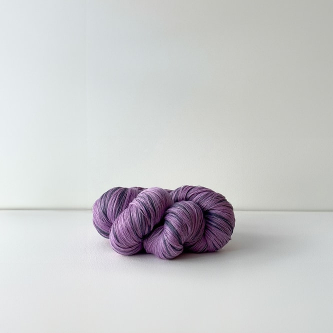 photograph of purple yarn-like linen braid in natural sunlight, in a white room