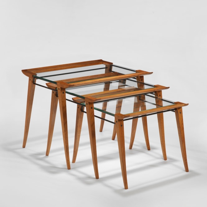 photograph of a set of three nesting tables, legs are made from wood and tops surface is glass