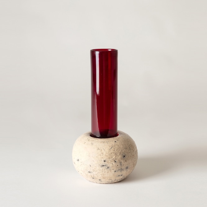 Red glass tubular vase sitting inside ROUNDED raku ceramic holder. 
