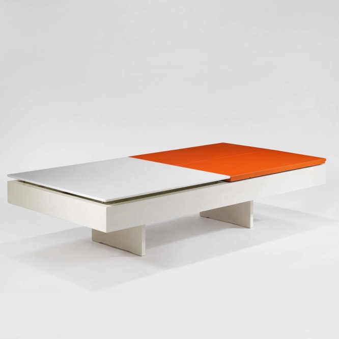 photograph of low table by Motte in a blank room, top of table is half orange and half white