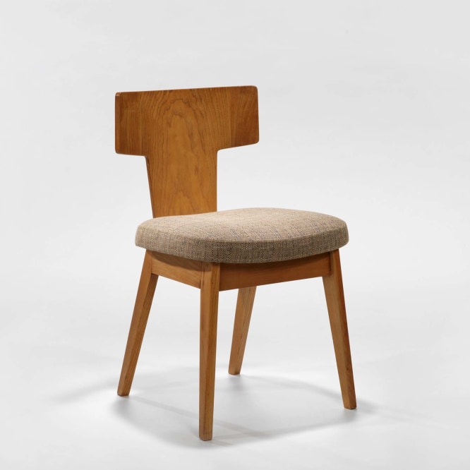 photograph of wooden chair with beige upholstery in a blank room
