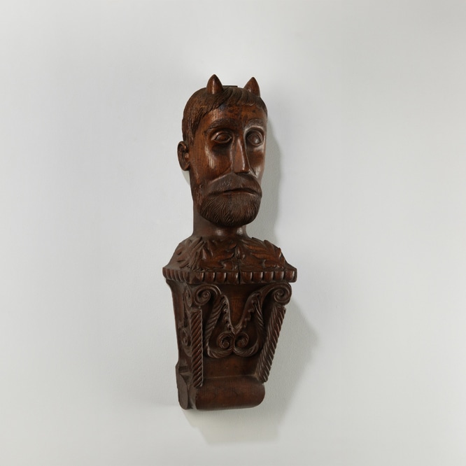 bust of a devil figure carved from wood