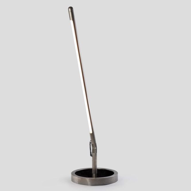 photograph of long metal floor lamp in a blank room