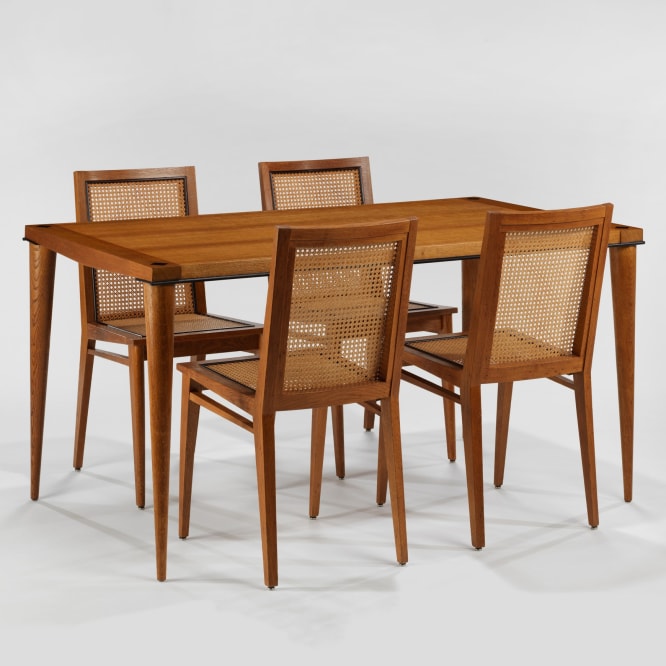 photograph of 4 wood chairs around a wood dining table in a blank room 