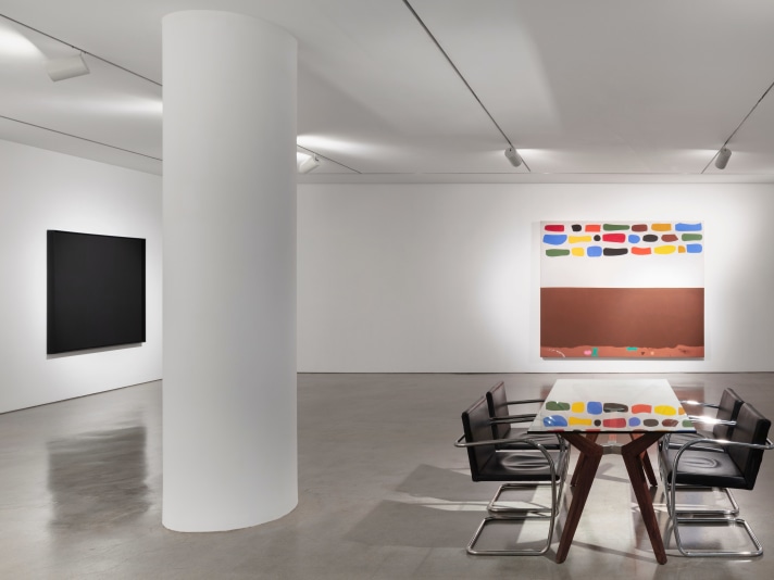 Installation view of black oil painting on canvas by Ad Reinhardt and an oil painting by Adolph Gottlieb of multiple color swatches and brown