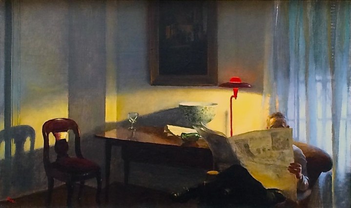 Image of sold oil painting entitled &quot;The Reader&quot; by John Koch showing a man sitting in an armchair reading the paper with light from a red lamp.