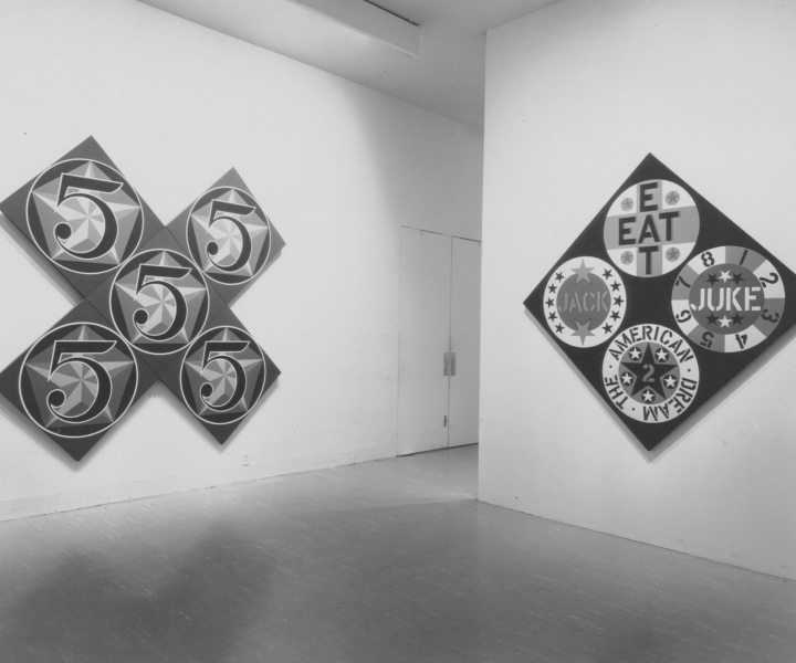 Installation view of the exhibition Americans 1963 with Robert Indiana's paintings The X-5, 1963, and The Black Diamond American Dream #2, 1962