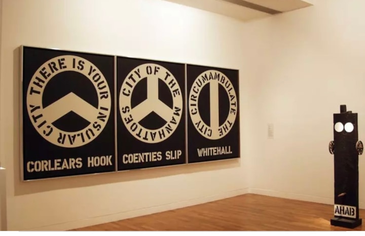 Installation view of Robert Indiana: Paintings and Sculpture, 1961 to 2003 at Waddington Custot Galleries featuring the painting The Melville Triptych and the sculpture Ahab