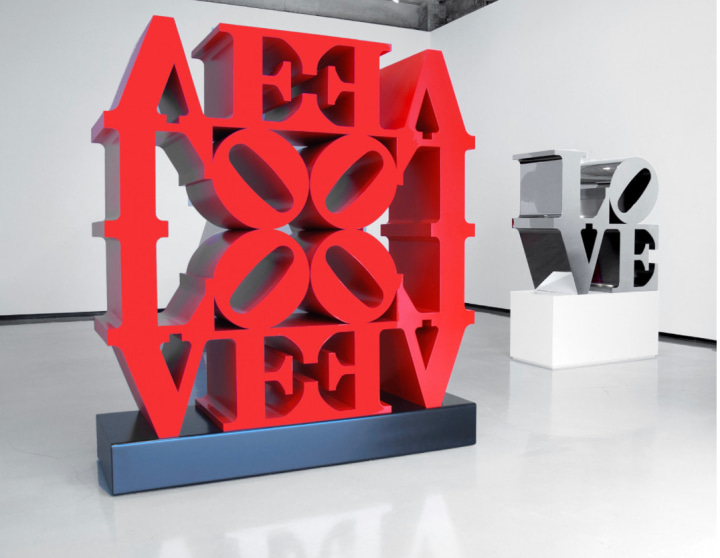 Installation view of Robert Indiana: Hard Edge at the Paul Kasmin Gallery with a red polychrome aluminum LOVE Wall and a stainless steel LOVE