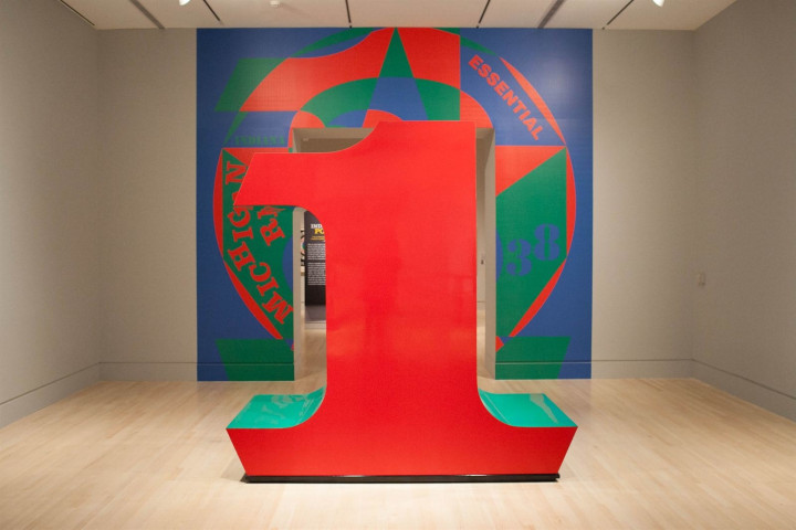 Installation view of The Essential Indiana at the Indianapolis Museum of Art with Indiana's large scale red and green polychrome aluminum sculpture ONE