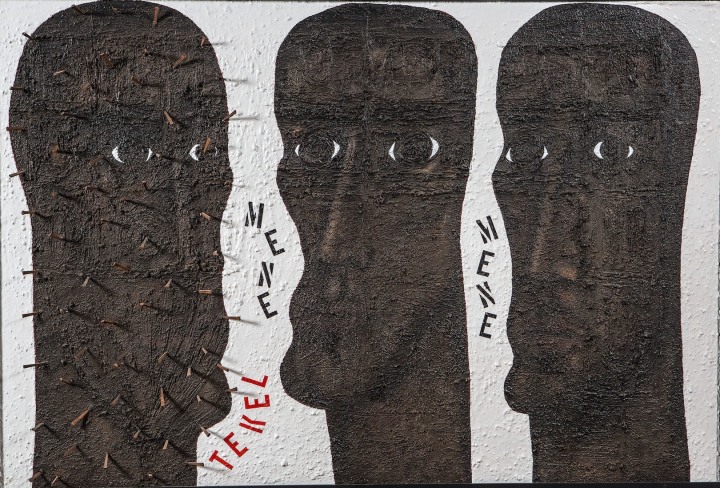 Mene Mene Tekel, a painting comprised of three dark brown totem like heads, the first has nails in it. in between the first two heads are the words Mene and Tekel; in between the second two heads is the word Mene