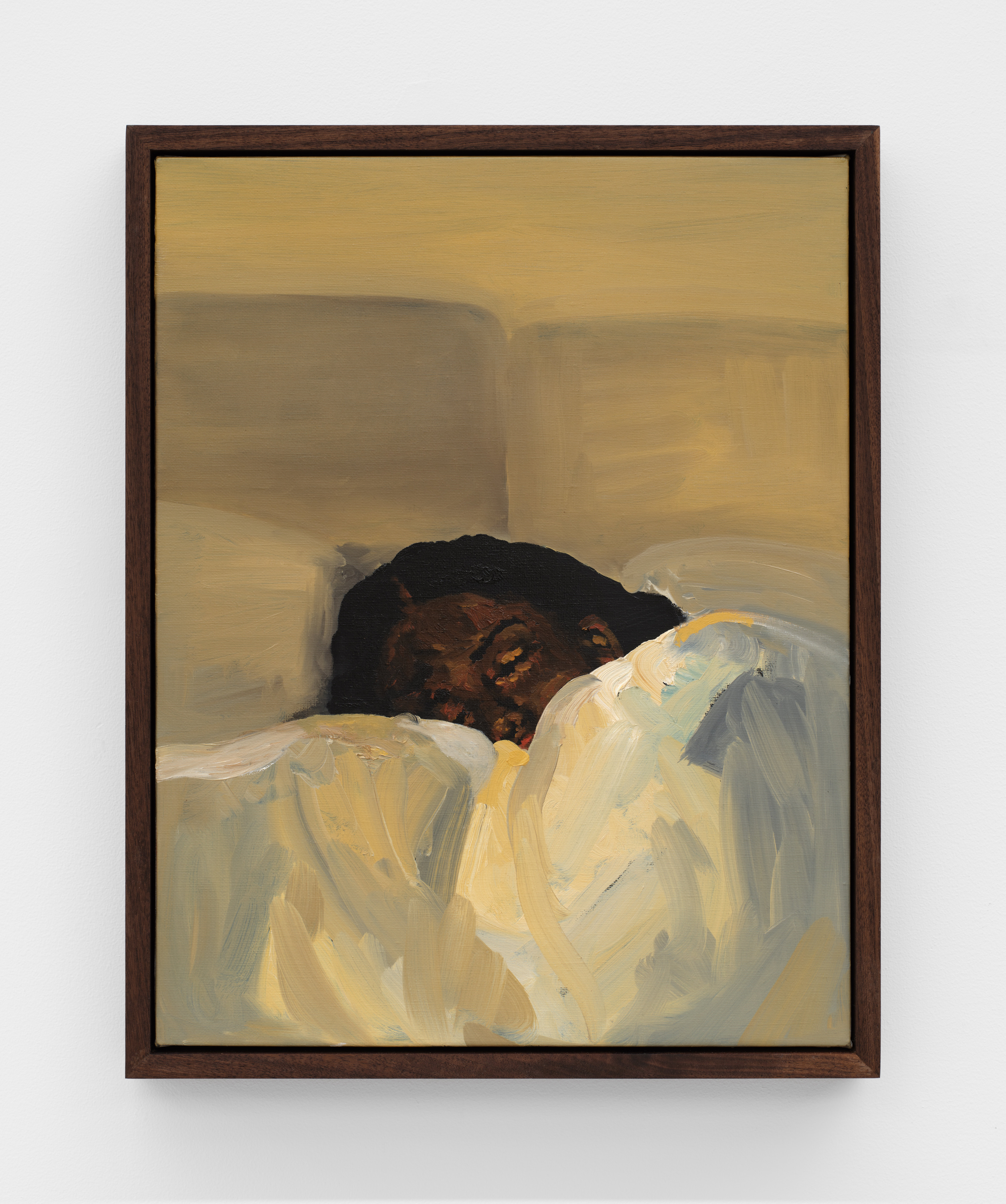A woman sleeps buried in pillows and blankets in soft yellow hues. 