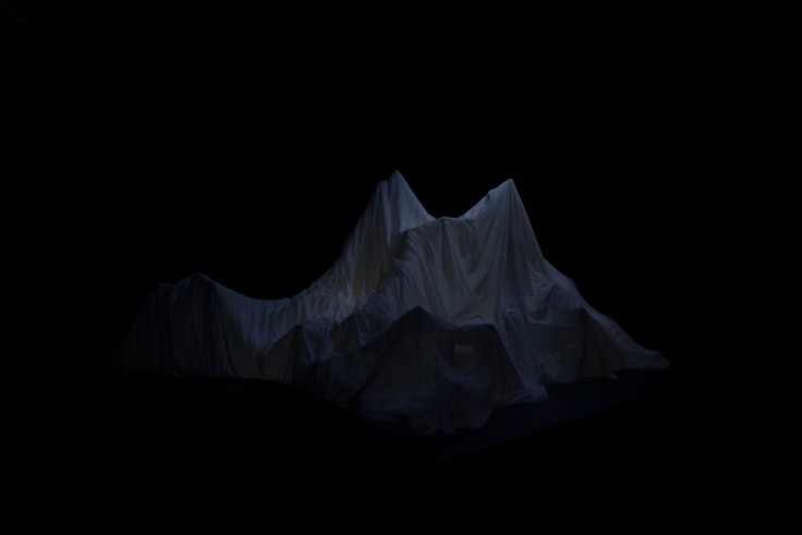 A sculpture of an iceberg shrouded in darkness