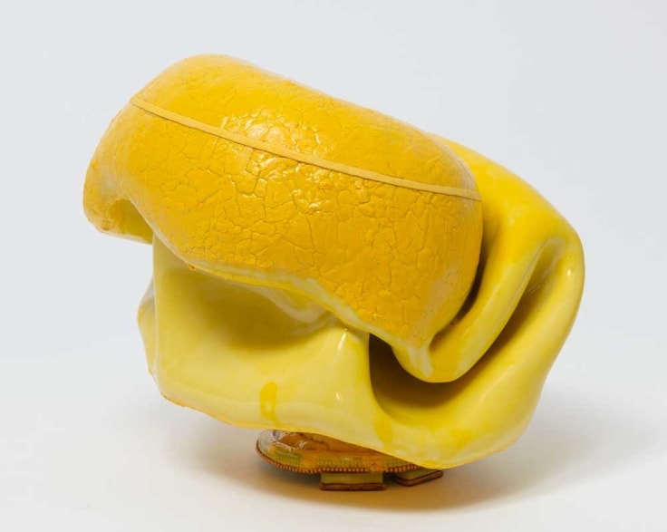 Organically-shaped clay sculpture with yellow glaze by Kathy Butterly.
