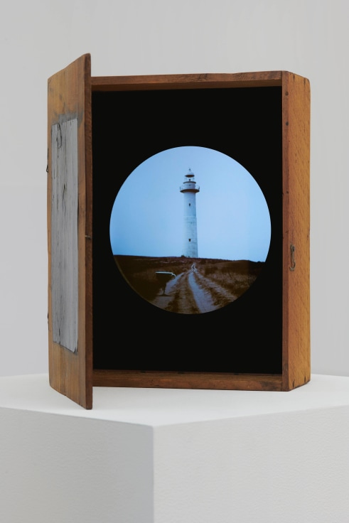 wooden box containing a circular image of a lighthouse