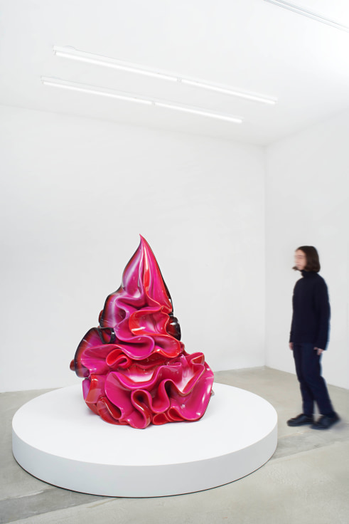 A fiberglass sculpture of a fluorescent pink dollop of whipped cream.