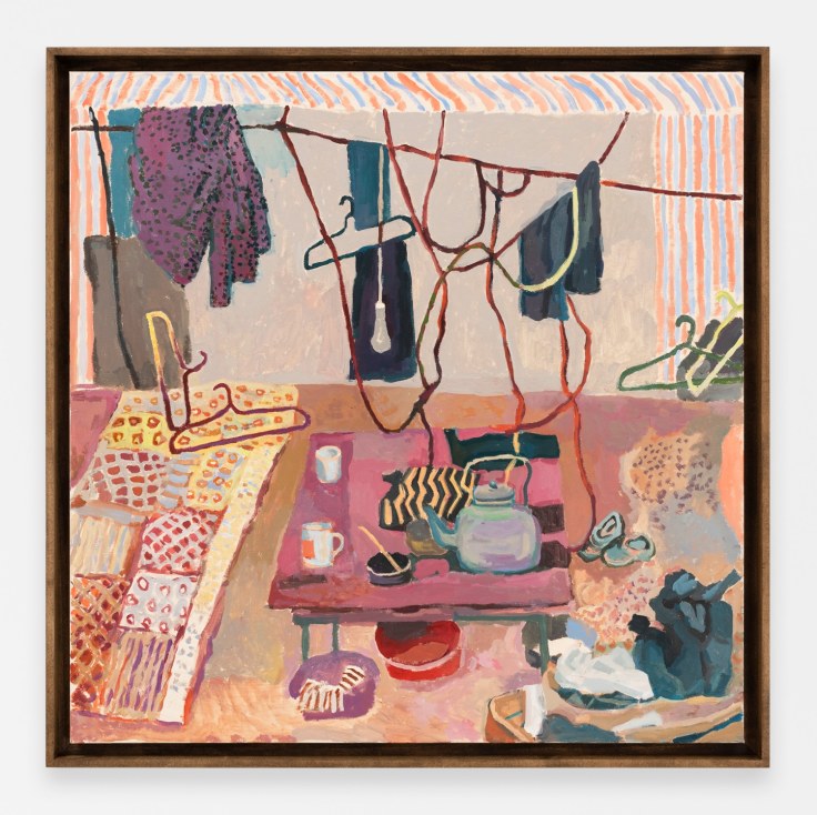 A room corner with dangling clothes hangers and basic living items
