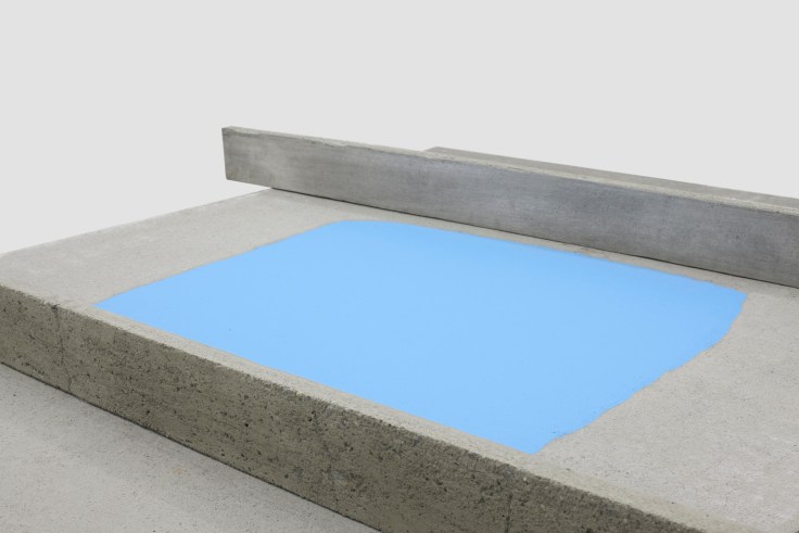 close up of a table's concrete surface witha blue shape painted in the middle