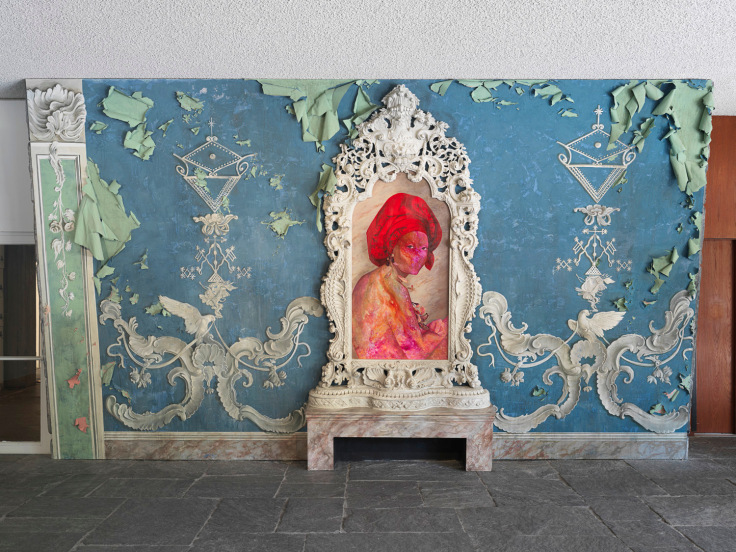 Wall insallation of a cosmically-colored figure wearing a red turban set in a gilded ivory frame by Firelei B&aacute;ez.