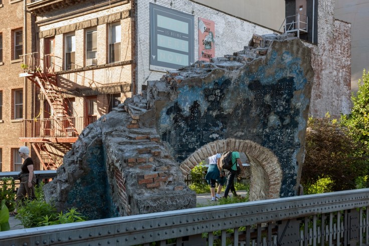 Installation of a crumbling blue arch in the middle of a garden bed by Firelei B&aacute;ez.