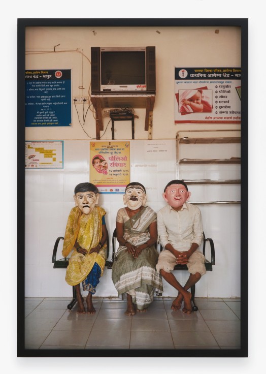 Archival pigment print featuring three seated people in paper Mache masks