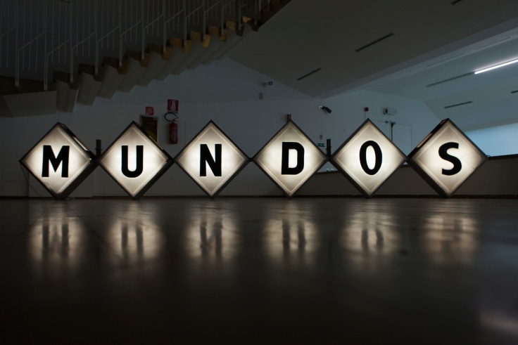 Six square neon signs placed on floor reads MUNDOS