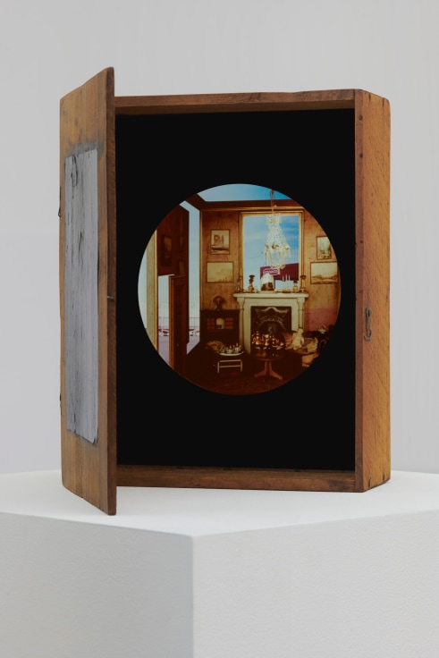 a wooden box containing a circular image of a Victorian style living room