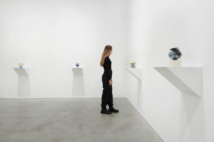 person looking at one of four artworks