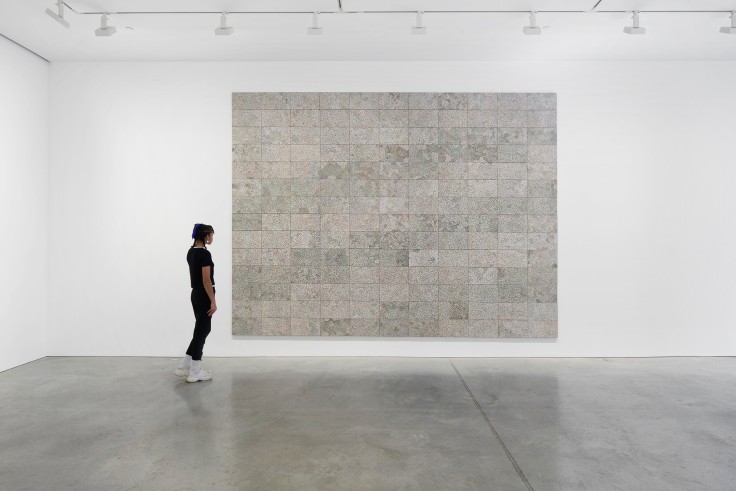 person observing a large artwork made of electronic components