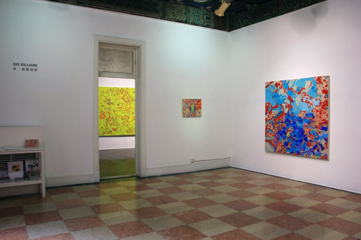 installation view of exhibition entrance with three abstract paintings