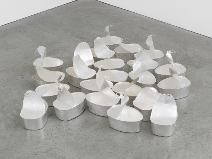 Image of an untitled sculpture by Michelle Grabner consisting 20 oversized steel ham tins of silver leaf with natural tarnishing
