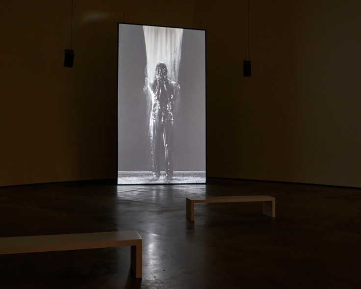 installation view of a video of someone getting soaked in water