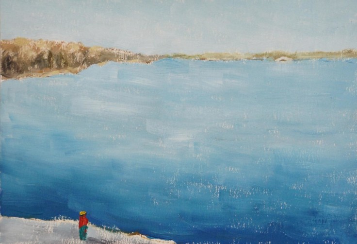 a solitary red figure looking over a large blue canal