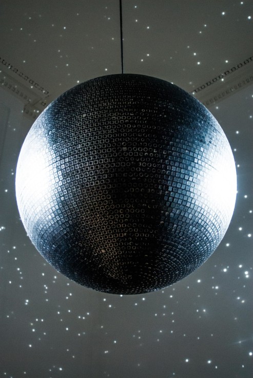 image of a disco ball lighting up a dark room with specks of light