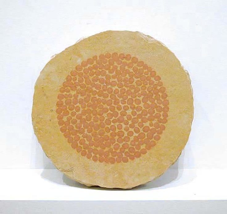 image of a round sculpture with orange dots in the center
