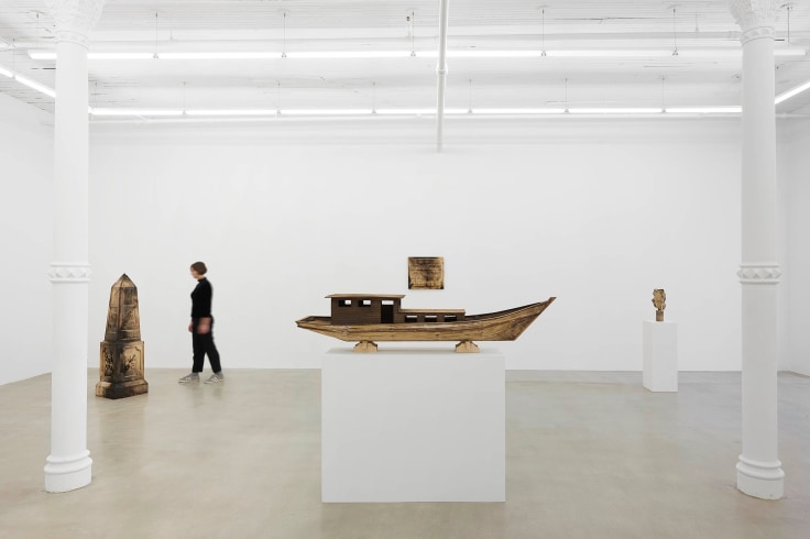 view of Tuan Andrew Nguyen's "A Lotus in a Sea of Fire" exhibition focusing on four wooden sculptures