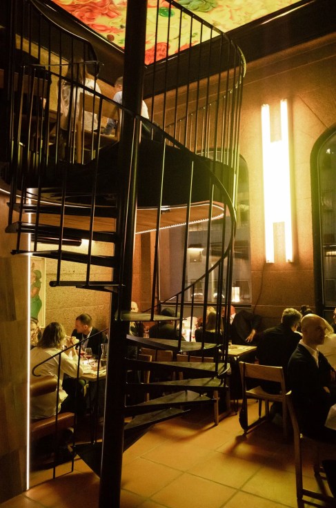 The restaurant was designed with a five-degree slant in the bar, the table bases, and the center pole of the spiral staircase. Felix Odell for The New York Times