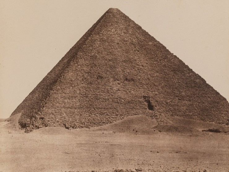 An Egyptian pyramid is photographed in this sepia-toned photograph.