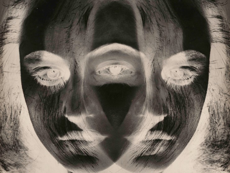 A black and white inverted image shows a young woman's face exposed twice and overlapping itself.