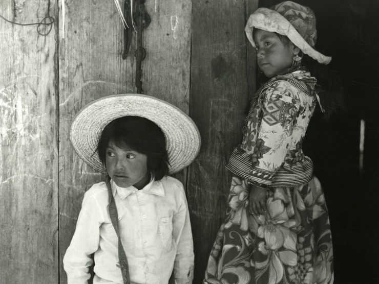 Two children wearing hats look off-camera in a black and white photo