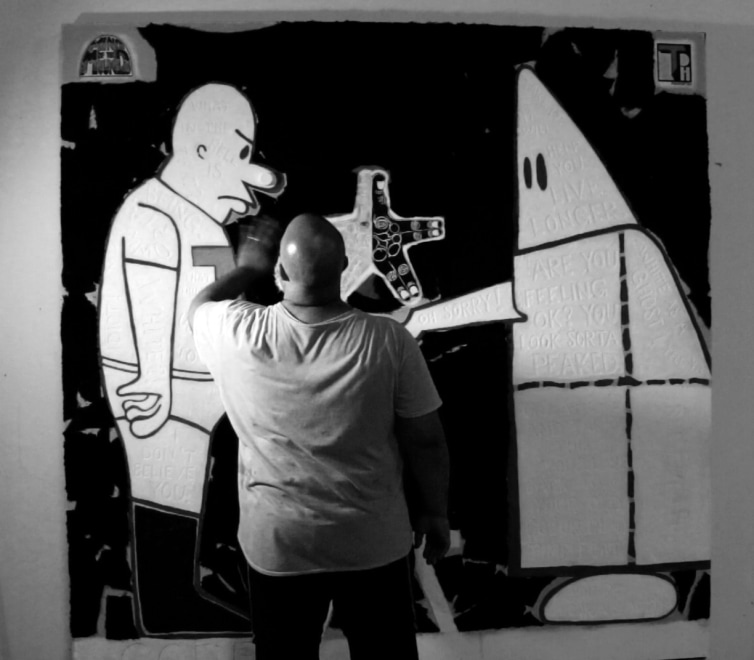 black and white image of artist standing in front of artwork