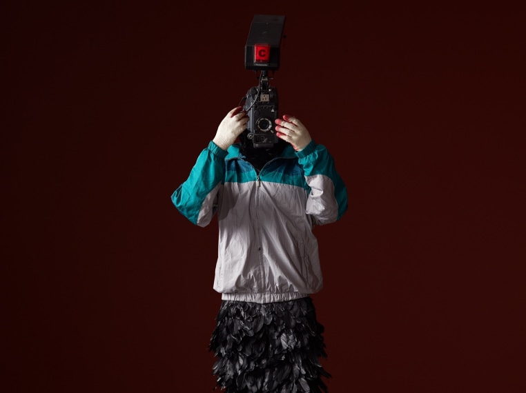 Minouk Lim (b. 1968) L'homme à la caméra, 2015 FRP mannequin, windbreaker, gloves, feathers, broadcast camera 88.58 x 26.77 x 22.83 inches 225 x 68 x 58 cm
