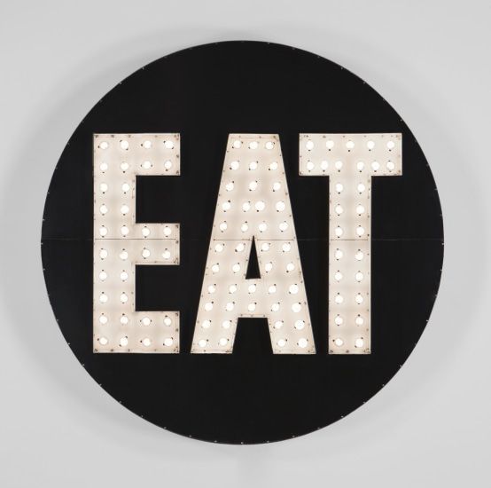Robert Indiana's The Electric EAT sculpture, an aluminum and stainless steel black circular sculpture with the word EAT in white with light bulbs.