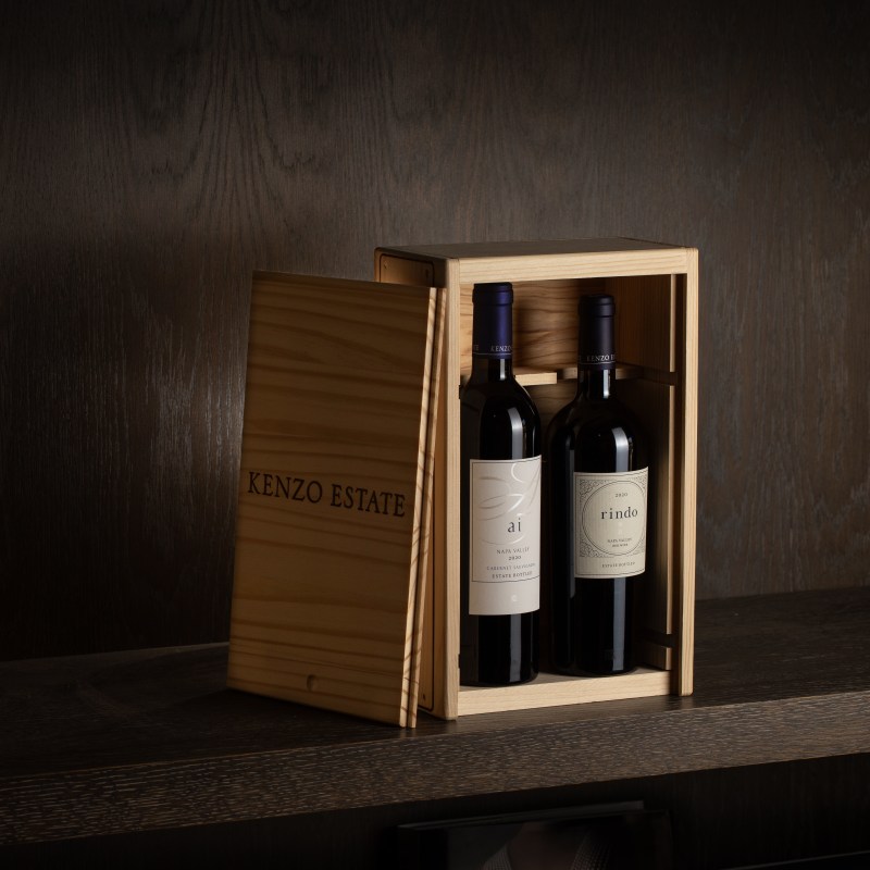 three half red wine bottles in a gift box with cedar sprig