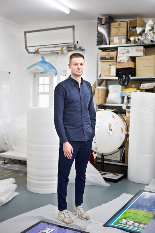 portrait of SImon denny standing in his studio