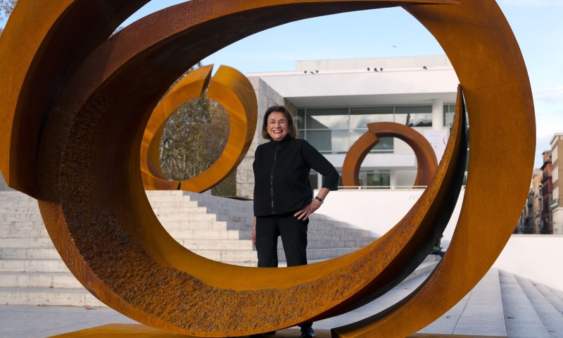 Color photographic portrait of Beverly Pepper with sculptures made with cor-ten steel from the curvae series
