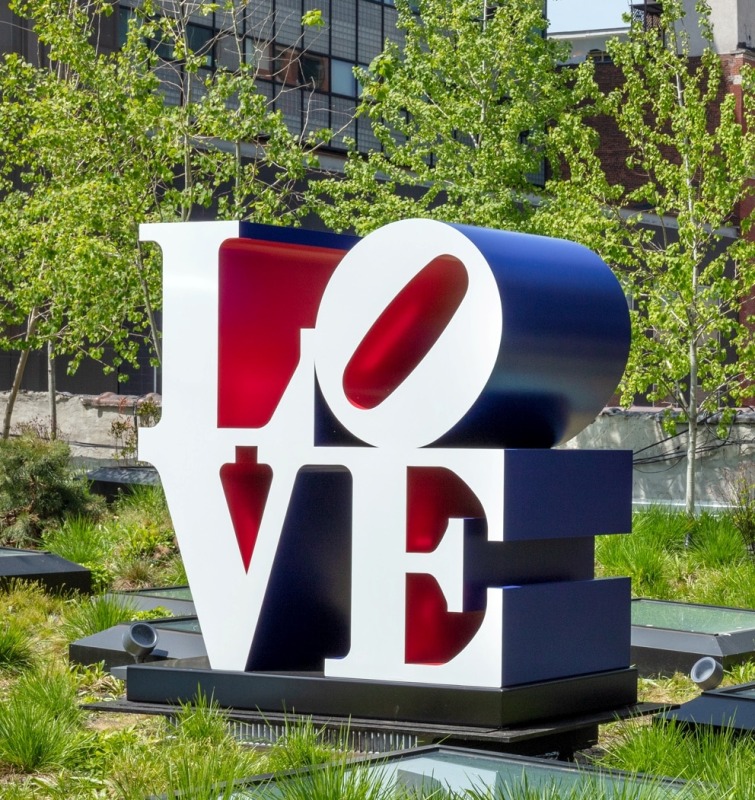 Installation view of a red white and blue polychrome aluminum LOVE sculpture, with the letter A and a tilted letter O on top of the letters V and E.