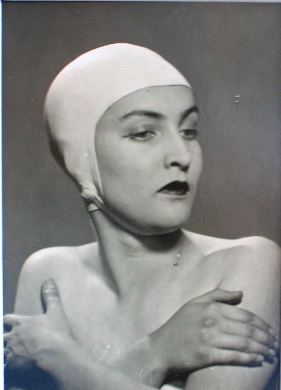 A woman wears a white swimming cap in a black and white photograph