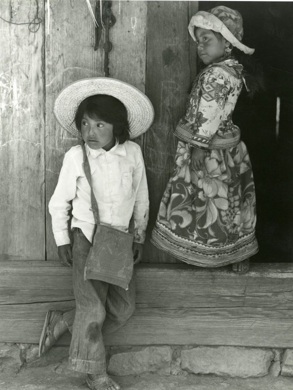 Two children wearing hats look off-camera in a black and white photo